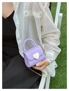 Detail view of purple mini jelly bag featuring a gold heart clasp and chain strap