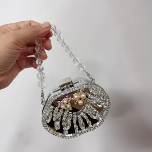 Detailed close-up of a luxury acrylic evening bag with sparkling rhinestones and pearls