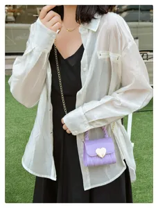Detailed view of a purple PVC jelly mini bag featuring a gold heart lock and chain strap