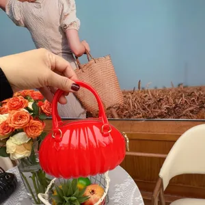 Gros plan détaillé d'un sac à main rouge en PVC en forme de citrouille en plein air