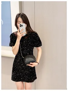 Elegant black shell-shaped evening clutch bag with a delicate metallic chain strap
