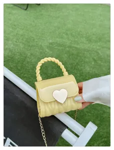 Close-up of yellow mini PVC jelly bag featuring a silver heart-shaped lock and chain strap