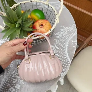 Vue détaillée d'un sac à main rose en PVC en forme de citrouille avec une finition brillante.