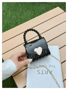 Detailed shot of a black mini PVC jelly bag featuring a golden heart lock strap.