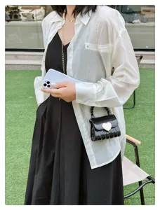 Chic mini black PVC jelly bag featuring a gold heart clasp and elegant chain strap.