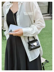 Close-up of a stylish black heart lock jelly bag worn by a model in casual outfit