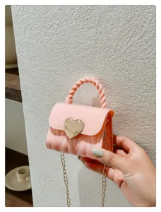 Close-up shot of a stylish pink mini jelly bag featuring a gold heart lock and chain strap