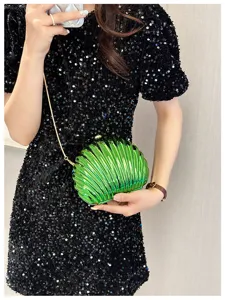 Close-up of a vibrant green shell-shaped evening clutch bag with a gold chain strap