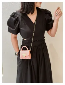 Model wearing a pink heart-lock mini PVC jelly bag for a sweet and stylish fashion look