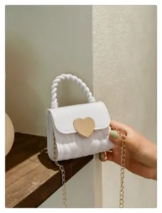 Detail view of a stylish mini white PVC jelly bag with a gold heart lock and chain.