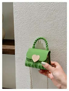 Close-up view of a mini green PVC jelly bag featuring a gold heart clasp and chain.