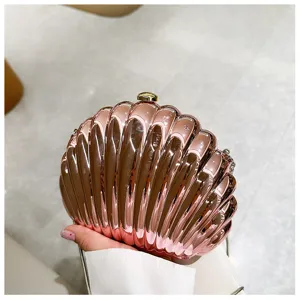 Detail of rose gold shell-shaped evening clutch with metallic finish.