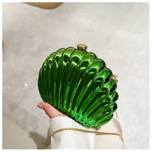 Glossy green shell-shaped clutch bag with gold chain strap for elegant evening wear