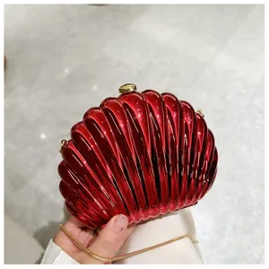 Close-up view of a vibrant metallic red shell evening clutch with gold chain strap