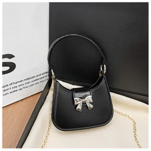 Detailed view of a stylish black PVC jelly bag with a silver bow and gold chain strap