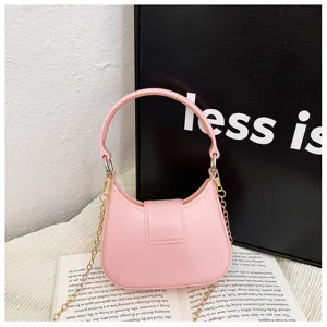 Chic pink PVC jelly handbag with gold chain strap in a lifestyle setting