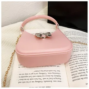 Macro view of a stylish pink PVC jelly bag featuring an elegant silver bow clasp and chain
