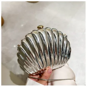 Close-up detail of a stylish silver shell-shaped evening clutch bag with metallic chain strap