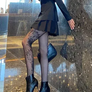 Detailed view of black floral fishnet tights, featuring intricate lace jacquard patterns.
