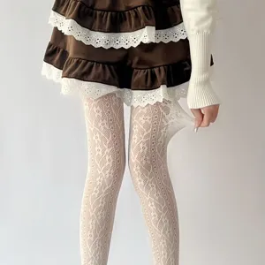 Close-up detail shot of white lace tights showcasing elastic stretch and floral pattern.