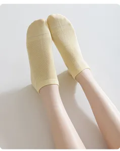 Close-up detail of women's yellow breathable mesh short socks for summer casual wear.