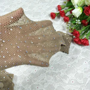 Detail shot of rhinestone fishnet stockings, nude mesh texture and sparkling crystal diamantes.