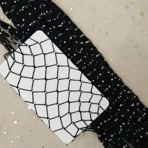 Detail view of black rhinestone fishnet tights, featuring sparkling crystals and mesh design.