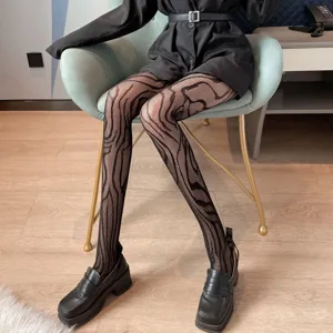 Women's trendy black fishnet pantyhose with chic abstract pattern, slim fit detail shot.