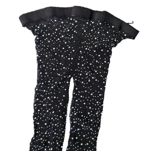Detailed view of women's black rhinestone fishnet tights, sparkling diamond mesh stockings.