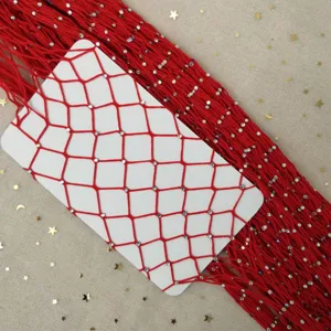 Detailed shot of red rhinestone fishnet stockings on a white card against a starry background.