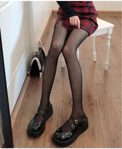 Sheer black pantyhose with delicate polka dots, perfect slim fit detail view for stylish outfits.