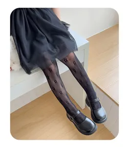 Dettagli in primo piano dei collant a rete neri da ragazza con motivi floreali delicati.