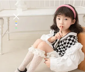 Detailed view of cute girls white lace mesh socks worn by child model with JK style outfit.