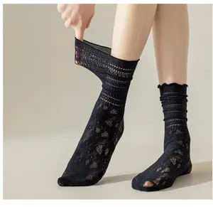 Gros plan détaillé de chaussettes slouch en dentelle noire montrant la texture en maille ajourée.