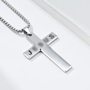 Macro view of beveled stainless steel cross necklace with hollowed JESUS letters