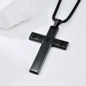 Detailed macro shot of black stainless steel cross necklace featuring hollow Jesus letters