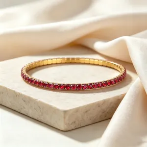 Close-up detail of a high-end gold-toned stainless steel elastic bracelet with red zircon