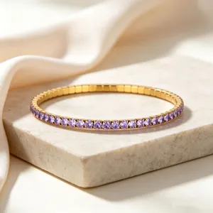 Close-up of golden stainless steel elastic bracelet with purple zircons