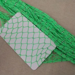 Detailed view of neon green rhinestone fishnet stockings, sexy hollow mesh pantyhose design.