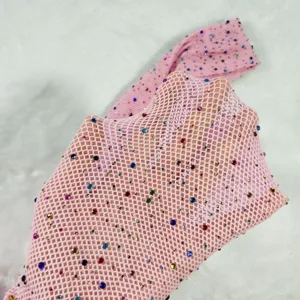 Close-up of pink fishnet tights with colorful rhinestones, showing texture and sparkle.
