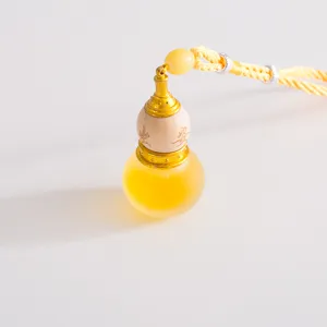Car aromatherapy essential oil pendant, gourd design, yellow glass bottle, wood and metal details.