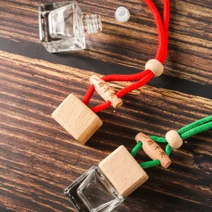 Dettaglio flacone profumo auto quadrato con vetro trasparente e tappo di legno colorato.