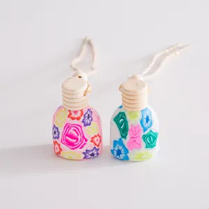 Nahaufnahme der Auto-Parfüm-Leereflasche aus Polymer-Ton mit buntem Blumenmuster und Holzdeckel.