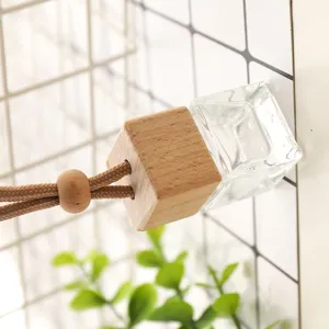Gros plan sur un flacon de parfum de voiture carré en verre avec bouchon en bois et corde.