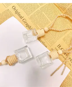 Detailed shot of empty square car perfume glass bottles with wood caps and ropes.