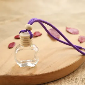 Detailed close-up of the transparent apple-shaped glass car perfume bottle with wooden cap.