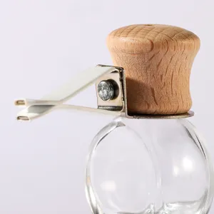 Detailaufnahme einer Autodüsen-Parfümflasche aus Glas mit Holzdeckel und Metallclip.