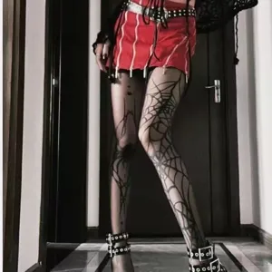 Gothic punk style spiderweb printed black tights, perfect for Halloween and alternative outfits.