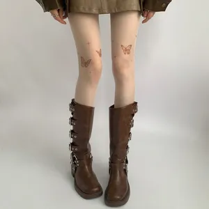 Sheer nude tights with cute butterfly tattoo print paired with stylish brown buckle mid-calf boots.