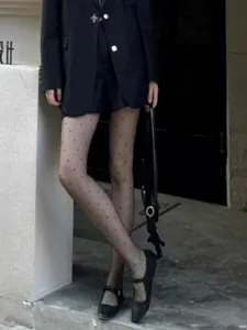Detailed view of sheer black polka dot pantyhose, ultra-thin sexy summer tights for women.